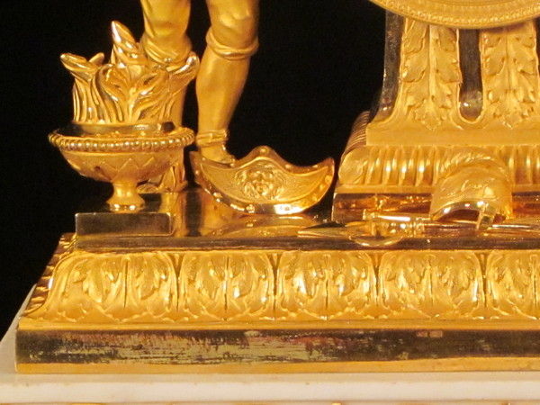 A fine fire-gilt mantel clock featuring a roman soldier and weapons.