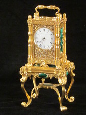 miniature engraved carriage clock on stand with malachite panels.